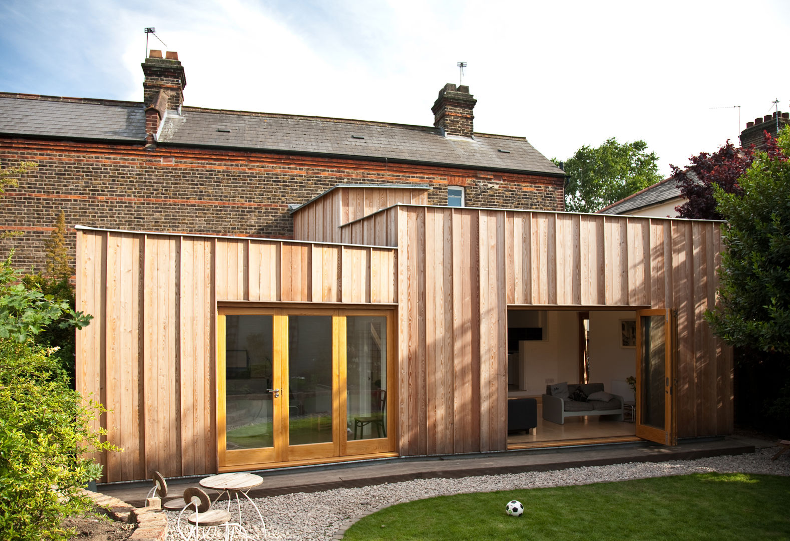 Rear elevation showing timber extension Neil Dusheiko Architects Casas modernas