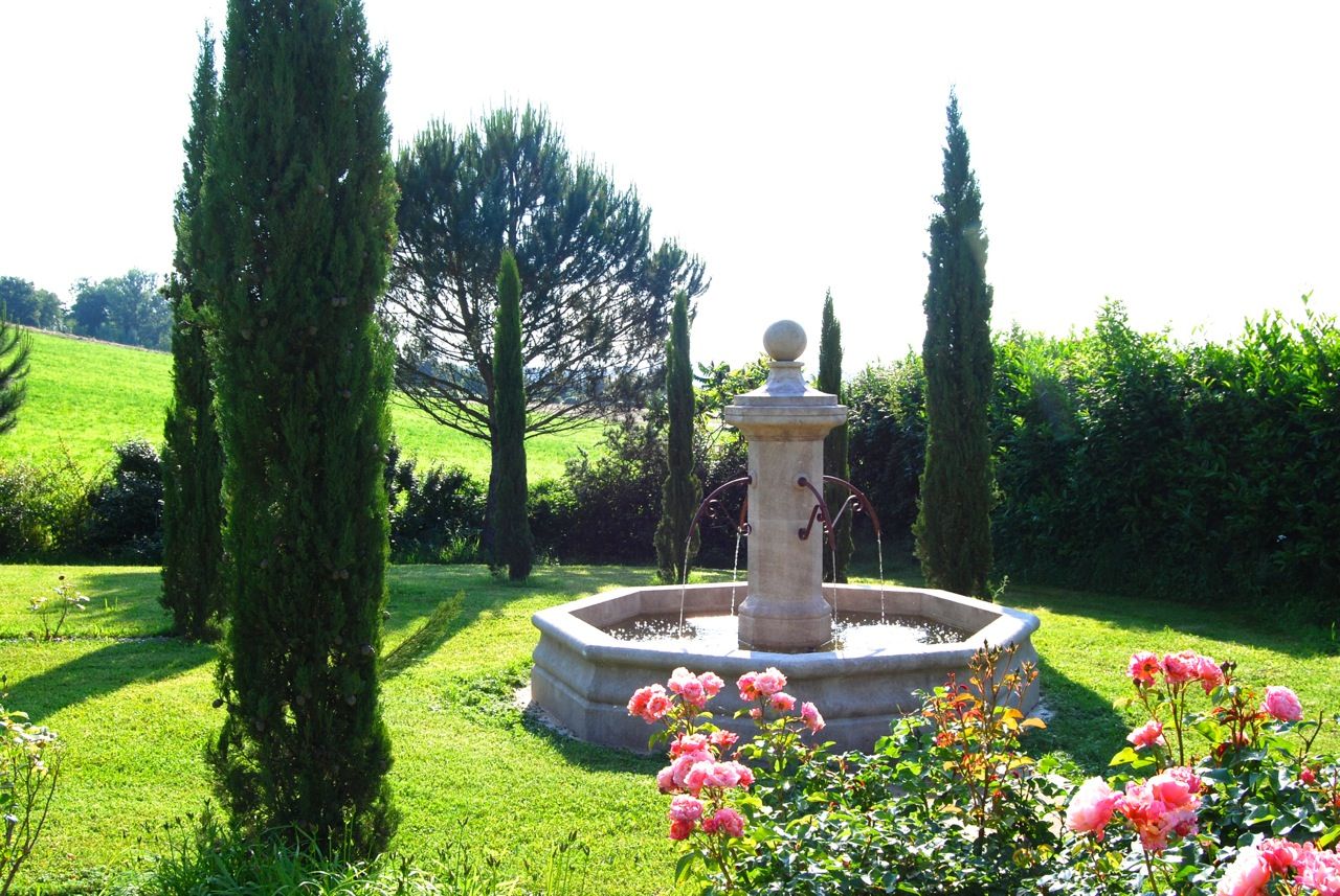 Fontaine centrale en pierre installée dans un jardin, Provence Retrouvée Provence Retrouvée Jardins mediterrâneos