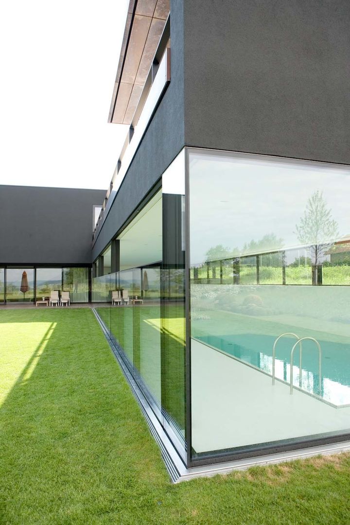 Descender Fronts - glass/glass corner fully raised homify Casas modernas