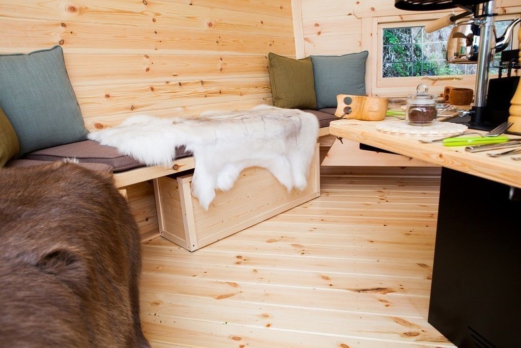 Seating and rugs inside a 10m² Barbecue Cabin in a Derbyshire garden. Arctic Cabins حديقة