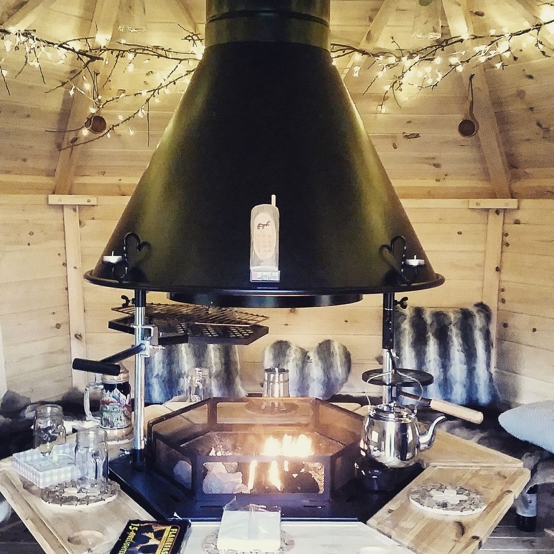 Looks so comfy - gorgeous lights, cushions and a real fire. Arctic Cabins Skandinavischer Garten