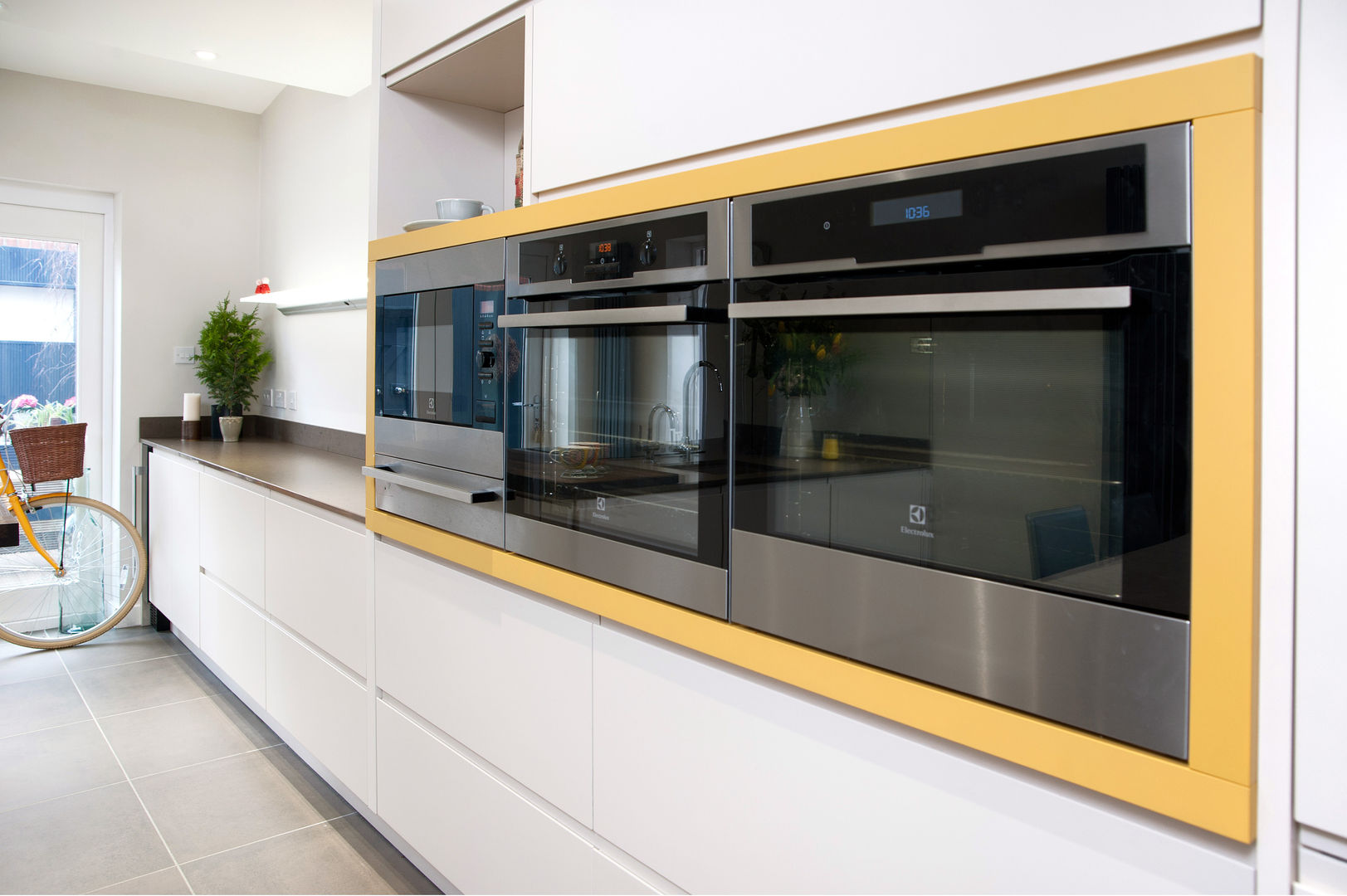 Electrolux appliances wrapped in Curry Yellow panelling Haus12 Interiors Cocinas de estilo moderno