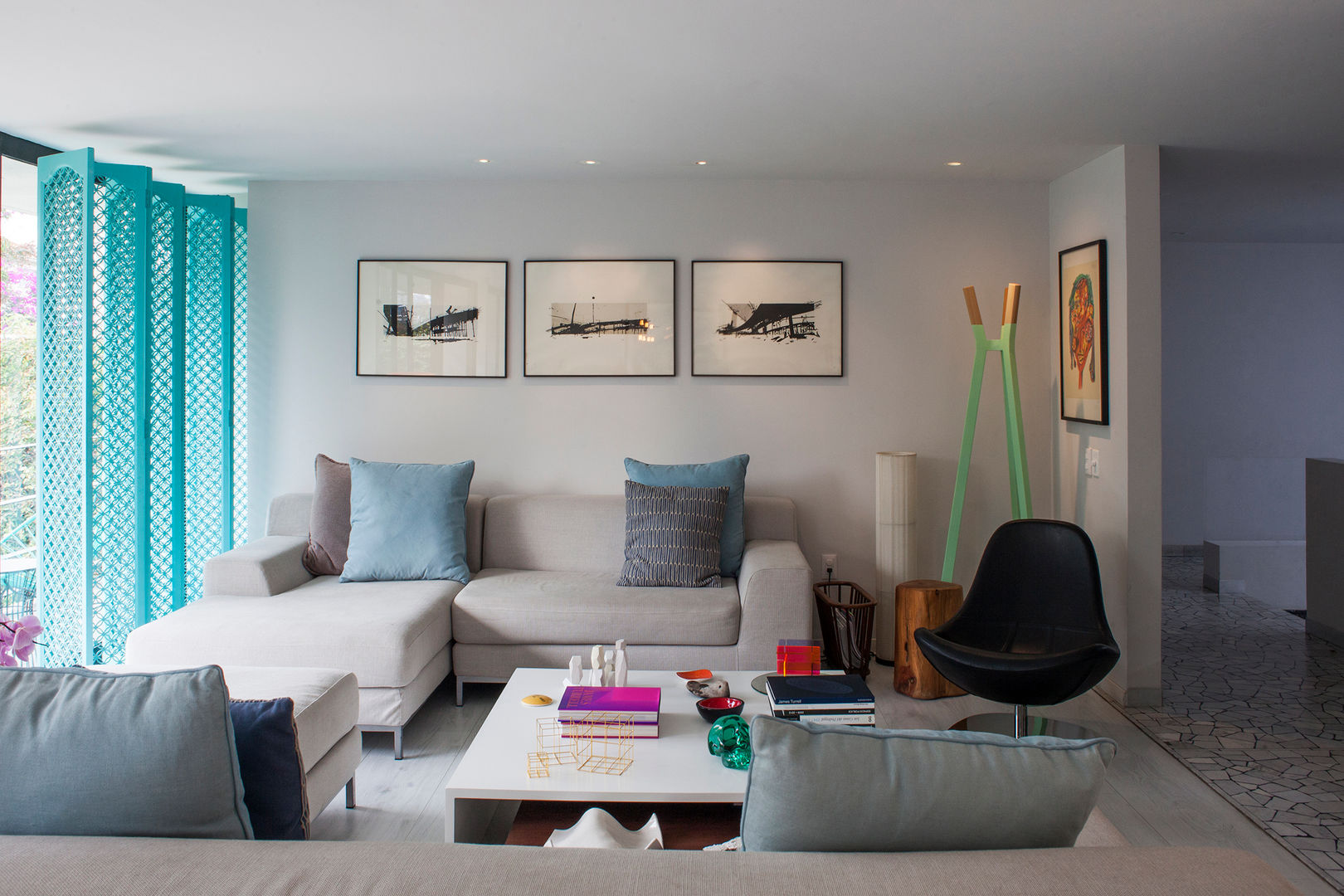 Cojines decorativos de color gris y turquesa en el sofá de una acogedora  sala de estar