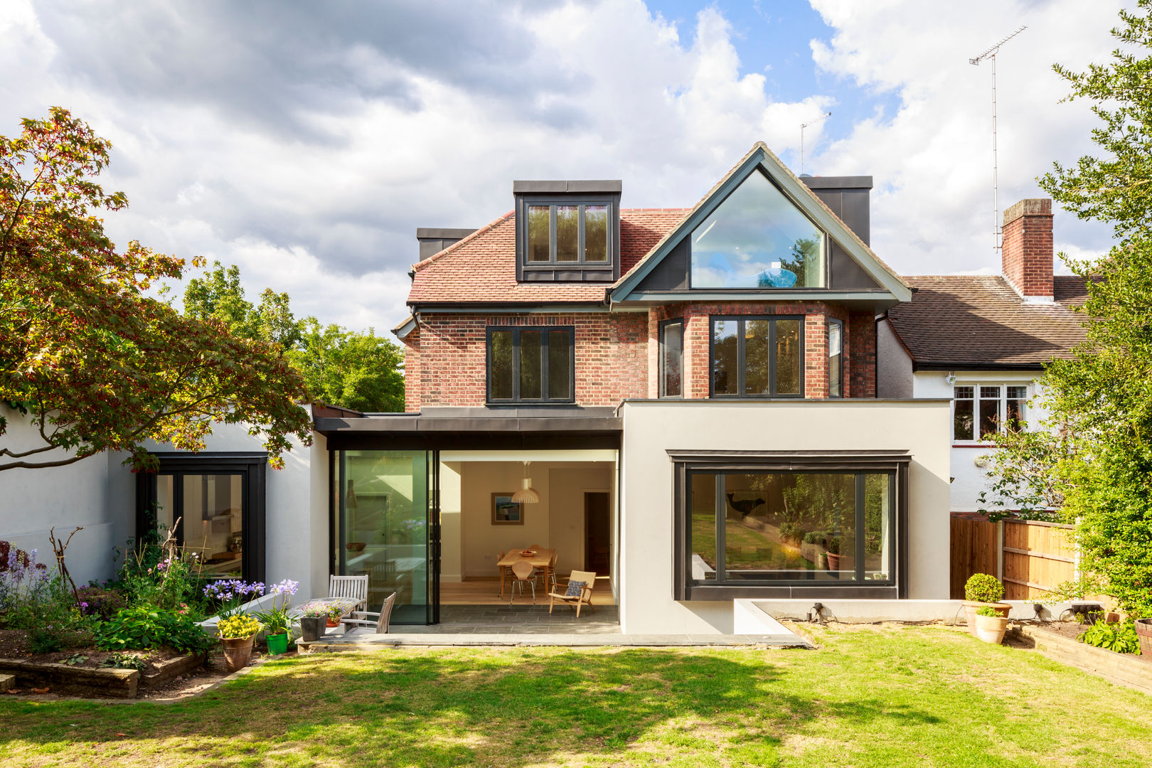 Rear view of extended and refurbished 1930s house in North London Jones Associates Architects 現代房屋設計點子、靈感 & 圖片 house extension, house refurbishment, modern extension, contemporary extension, house renovation, rear extension, roof extension, 1930s house, North London house extension, North London house refurbishment, Crouch End house extension, Crouch End house refurbishment, Crouch End house renovation, Crouch End house alterations, Crouch End architect, Muswell Hill house extension, Muswell Hill house refurbishment, Muswell Hill house renovation, Muswell Hill house alterations, Muswell Hill architect, N10 house extension, N10 house refurbishment, N10 house renovation, N10 house alterations, N10 architect, sliding glass doors, zinc roof, glass gable, zinc dormer