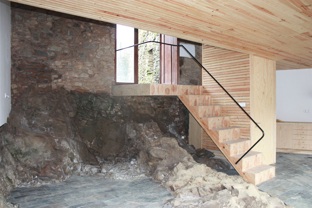 Vista da escada com o afloramento rochoso Atelier do Corvo Salas de estar modernas