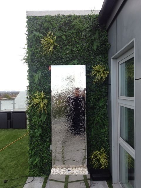 Artificial green wall with mirrored water feature Evergreen Trees & Shrubs حديقة نباتات و زهور