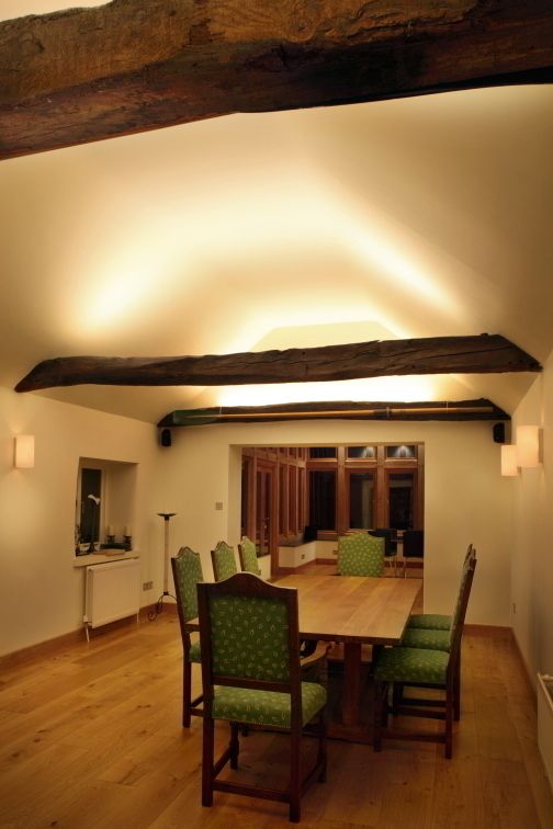 View of dining room into oak-framed extension Sam Coles Lighting Їдальня