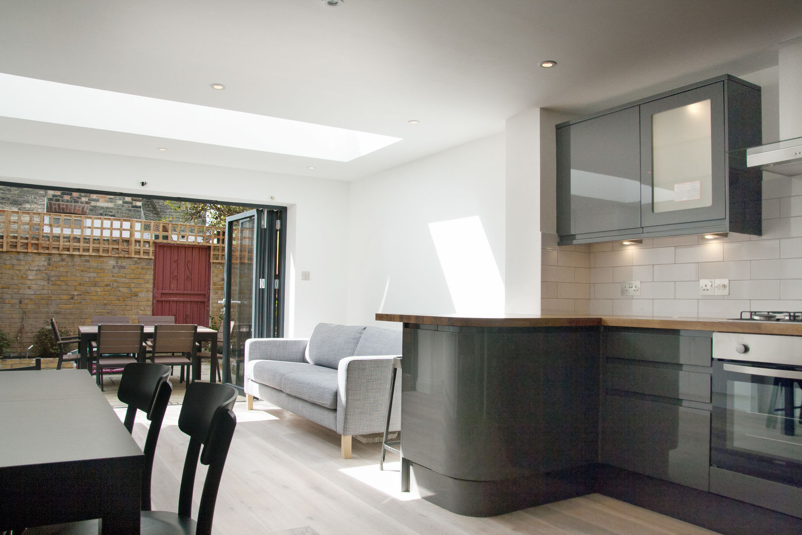 Open plan kitchen and living room GK Architects Ltd Salas modernas