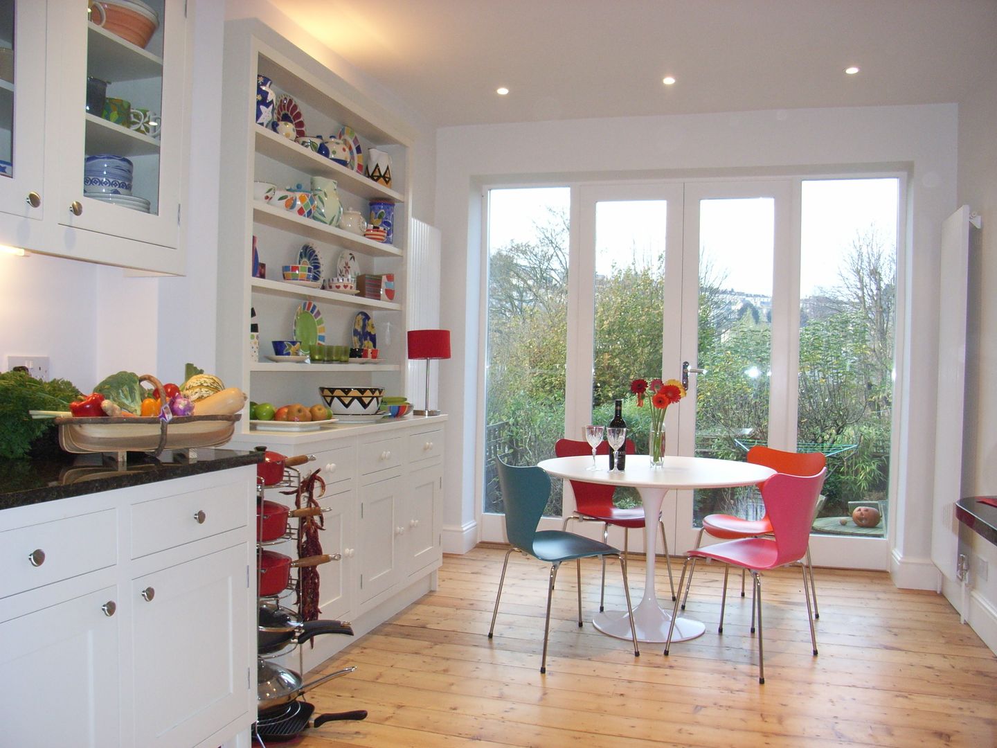 Kitchen Diner overlooking garden Style Within Cocinas de estilo clásico Madera Acabado en madera open plan kitchen,kitchen diner,handpainted kitchen,ivory kitchen,white kitchen,shaker kitchen,handmade kitchen,garden room,tulip dining table,granite worktop,stripped floor,knock through