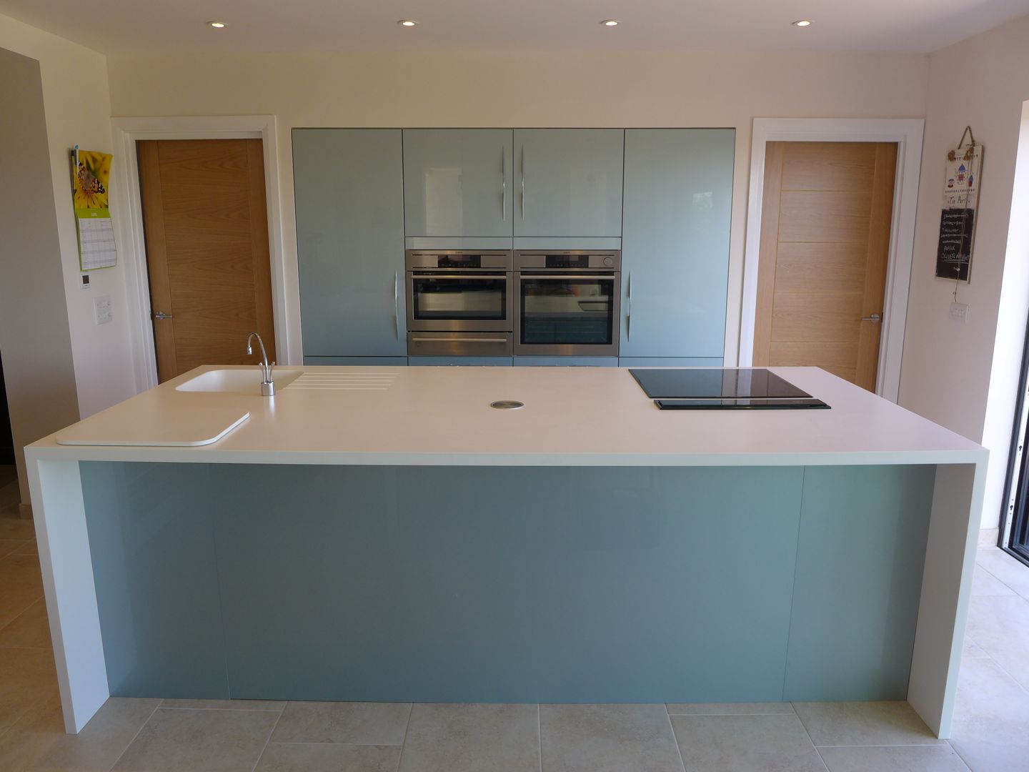 Ice-Blue Gloss Kitchen Style Within Cocinas de estilo moderno kitchen,blue kitchen,kitchen island,large island,gloss kitchen,porcelain tile floor,acrylic worktop,kitchen worktop,tall kitchen units,induction hob,breakfast bar,home lighting