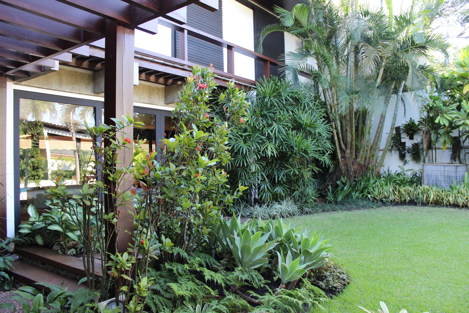 Fachada da residência homify Jardins tropicais