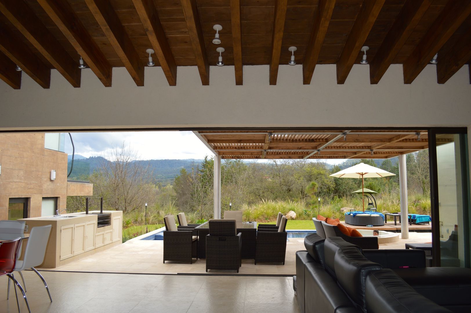 Vista desde la estancia hacia el exterior. El cancel corredizo permite la integración total de la terraza con la estancia. Revah Arqs Balcones y terrazas modernos