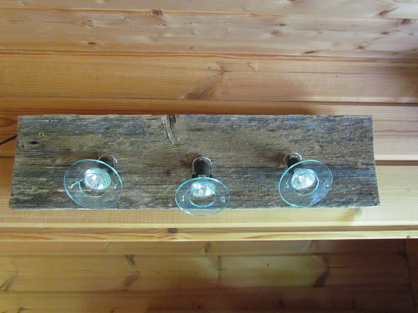 Halogenspots auf einem Kelo-Brett homify Rustikale Wohnzimmer Holz Holznachbildung Licht,Beleuchtung,Lampe,Wandlampe,nordisch,skandinavisch,Finnland,Lappland,Holzlampe,Holz,Holzarbeit,Beleuchtung