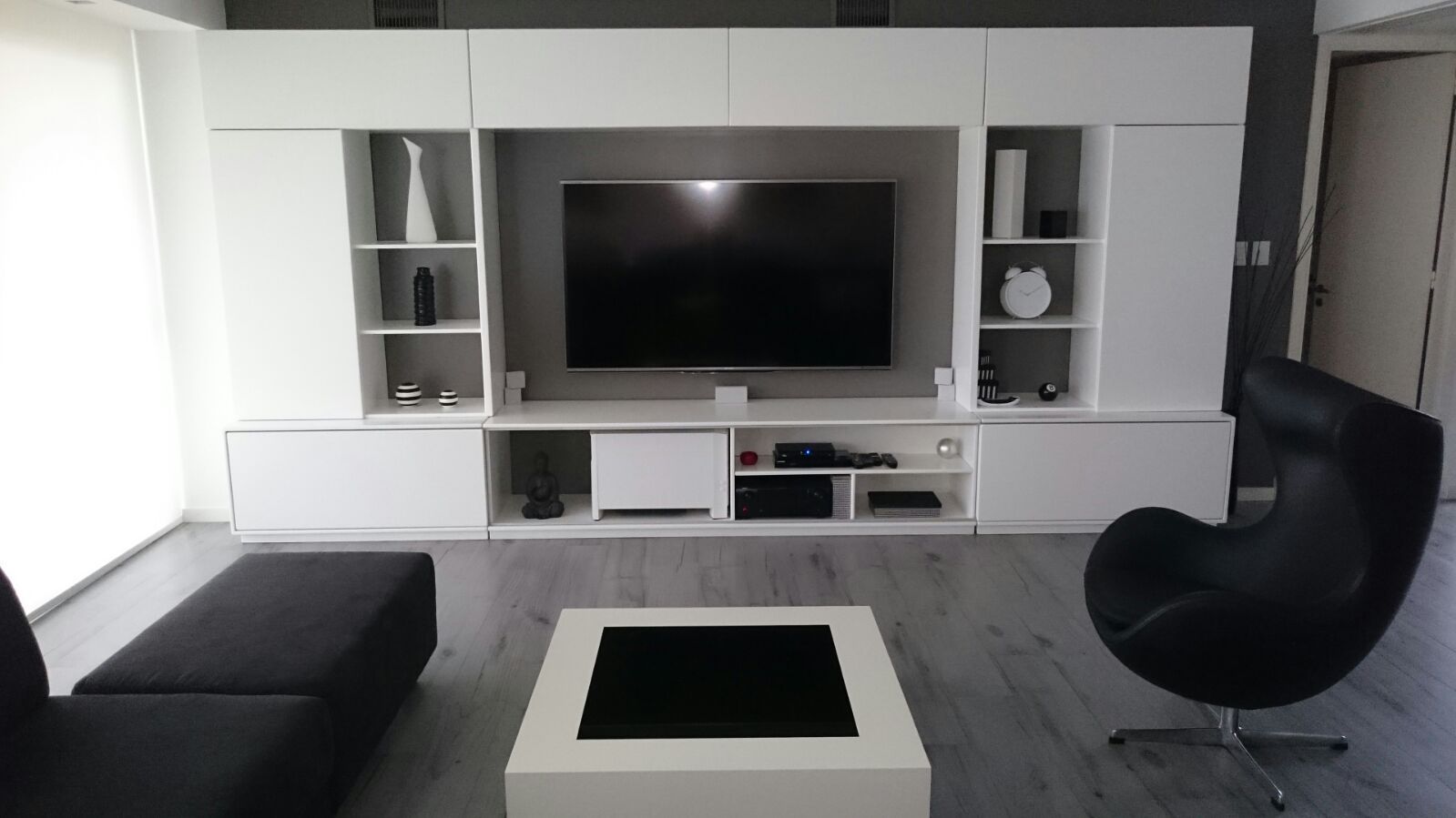 Entre el blanco y el negro los grises se hacen presentes en este living moderno. dymmuebles Salas de estilo moderno Estanterías