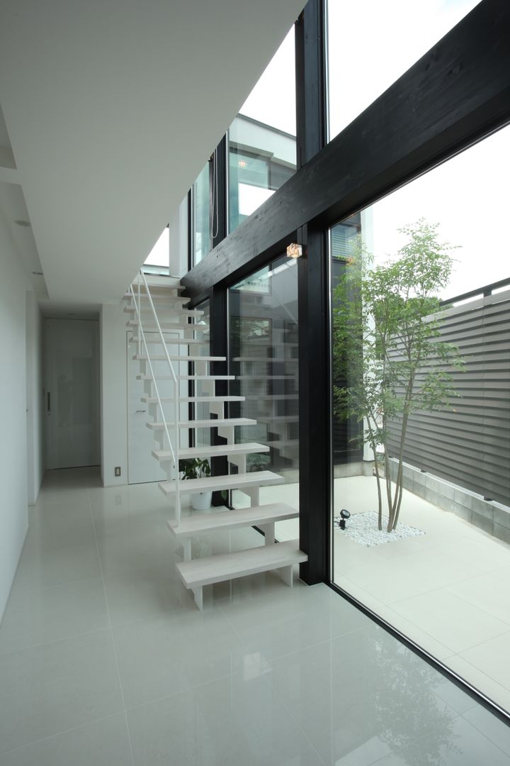 白い階段+ プライベートヤード TERAJIMA ARCHITECTS／テラジマアーキテクツ モダンスタイルの 玄関&廊下&階段
