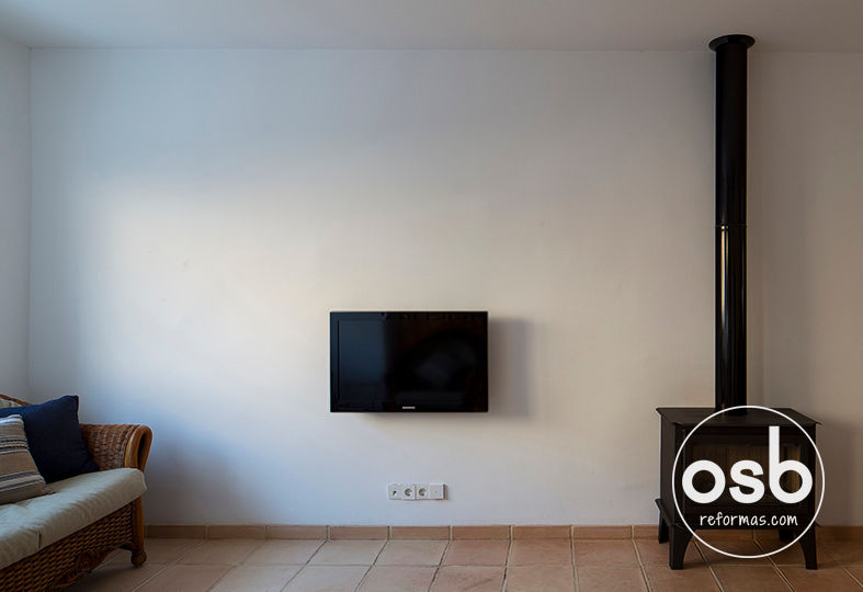 Televisión colgada en la pared osb arquitectos Salones clásicos