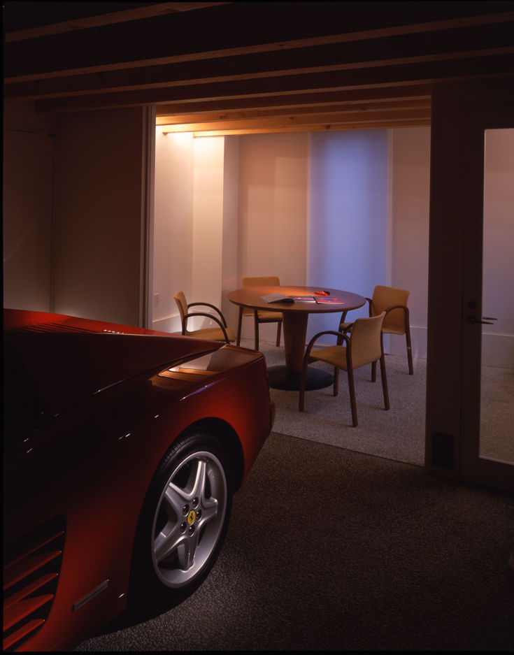 ガラススクリーン越しに趣味の部屋から車庫の中の愛車を眺められる Guen BERTHEAU-SUZUKI Co.,Ltd. モダンデザインの ガレージ・物置