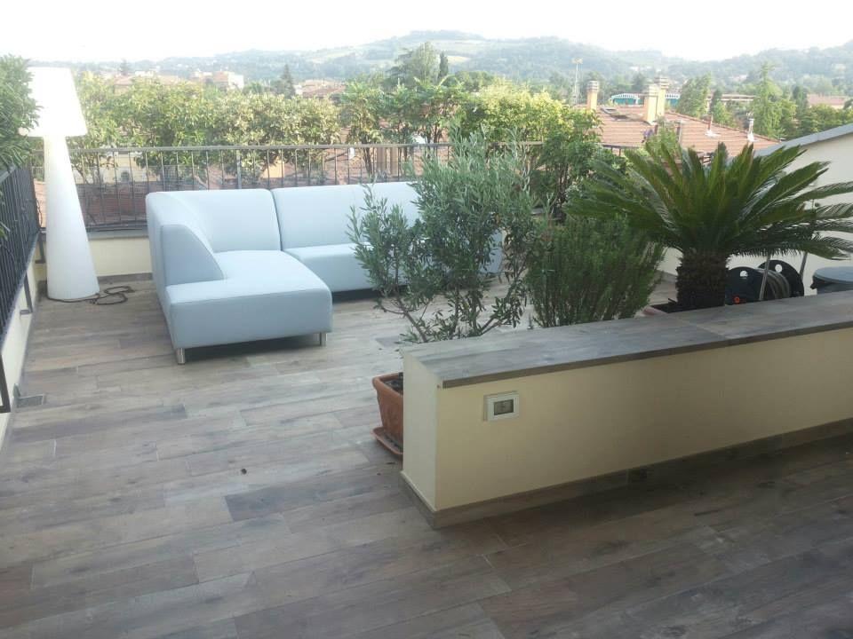 Terrazza esterna presso abitazione privata - Bologna centro Benuzzi srl Balcone, Veranda & Terrazza in stile moderno Ceramica Tavolo,Pianta,Cielo,Divano,Mobili da esterno,Interior design,Architettura,Albero,Costruzione,Legna