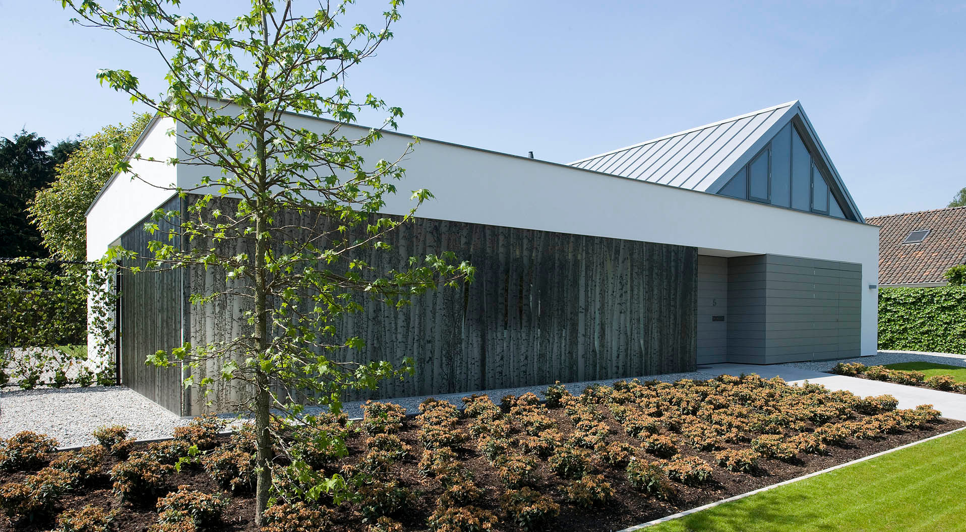 Voorgevel met translucente glazen wand met berkenboomstammen OTTENVANECK architecten & vormgevers