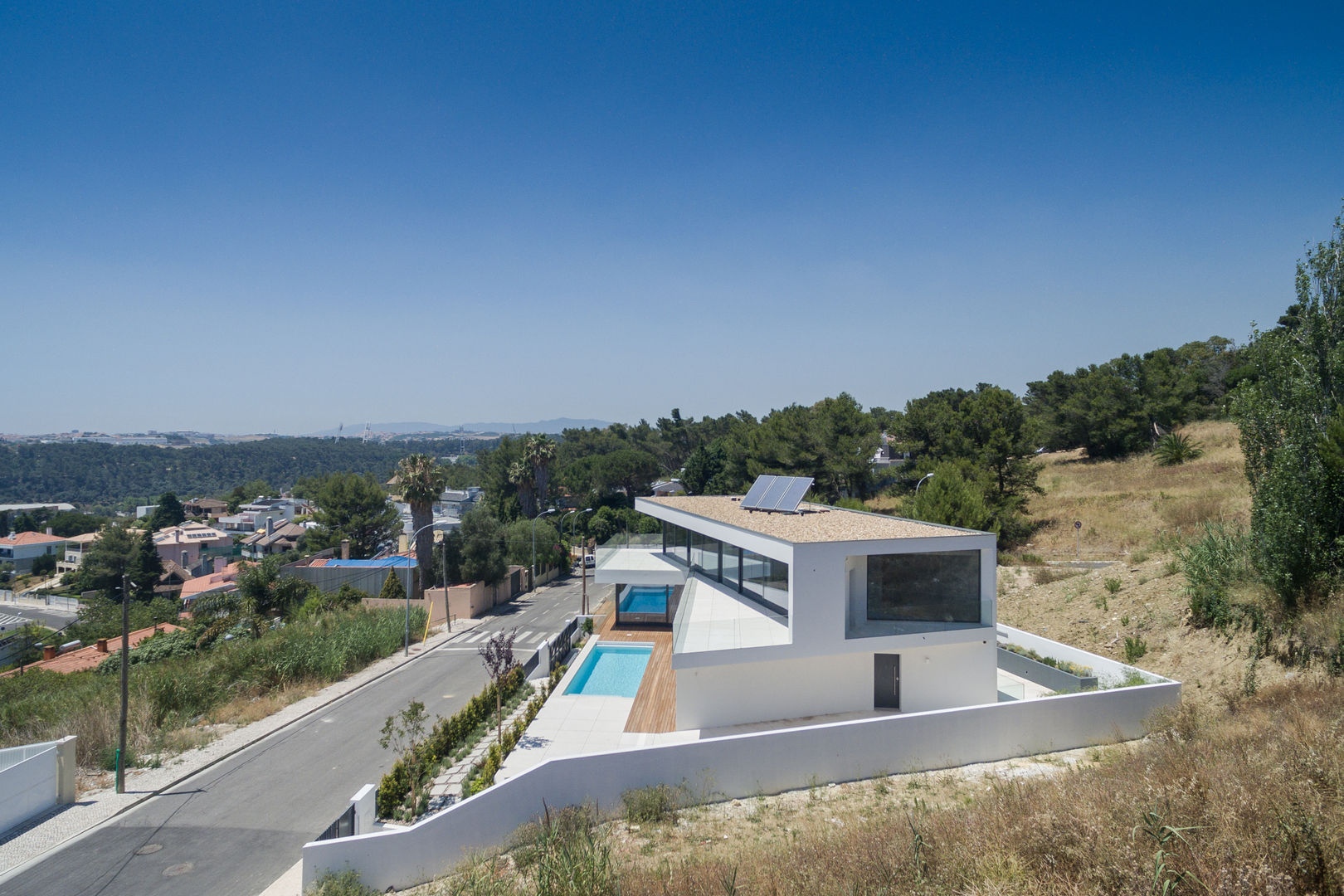 Moradia de grandes planos envidraçados aproveita exposição solar e vistas panorâmicas, JPS Atelier - Arquitectura, Design e Engenharia JPS Atelier - Arquitectura, Design e Engenharia モダンな 家