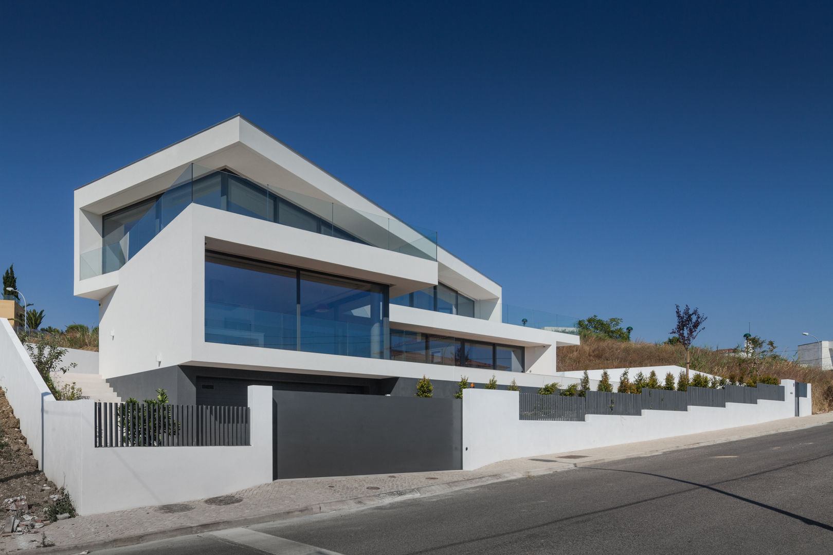 Moradia de grandes planos envidraçados aproveita exposição solar e vistas panorâmicas, JPS Atelier - Arquitectura, Design e Engenharia JPS Atelier - Arquitectura, Design e Engenharia Maisons modernes