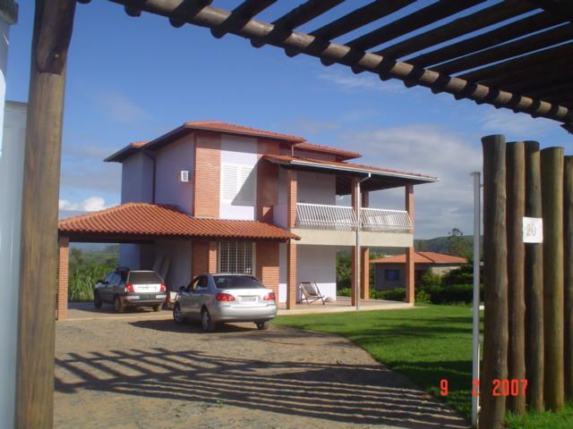 Em terreno plano, em um condomínio fechado em uma área rural. Casa de final de semana para casal com dois filhos adultos. homify Casas tropicais