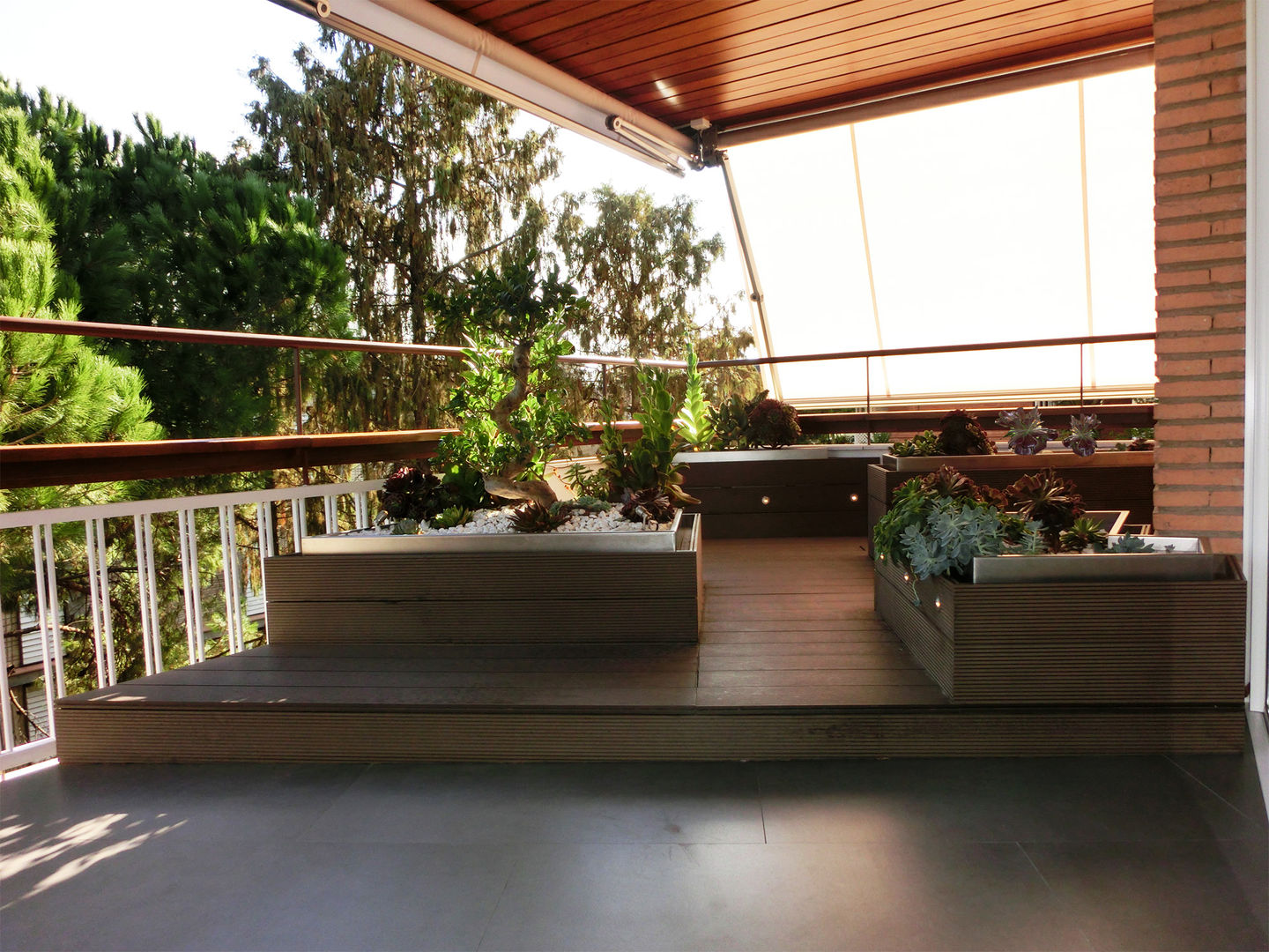 Terraza reformada con tarima y macetas de lamas sintéticas. homify Balcones y terrazas asiáticos