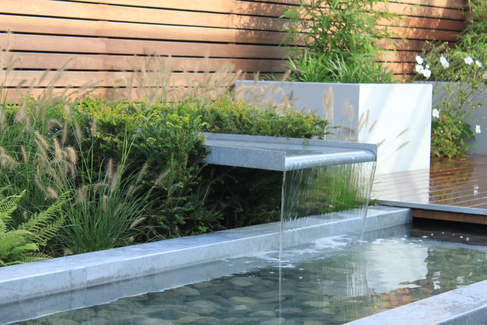 Patiogarden with steel pond and water feature Hoveniersbedrijf Guy Wolfs Moderne tuinen
