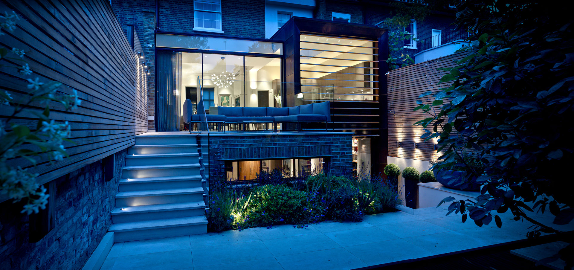 ​Garden Terrace at Newton Road House in the evening. Nash Baker Architects Ltd Modern balcony, veranda & terrace