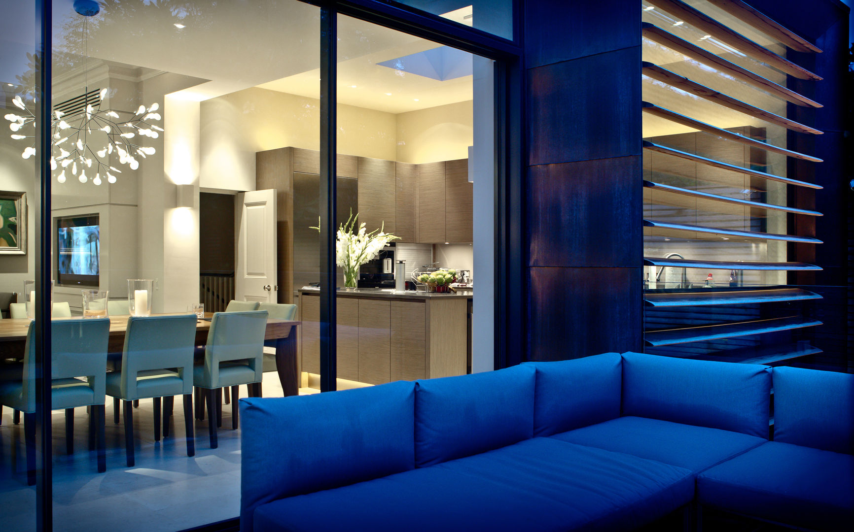 ​Garden Terrace at Newton Road House in the evening looking in to the kitchen and dining area. Nash Baker Architects Ltd Varandas, alpendres e terraços modernos