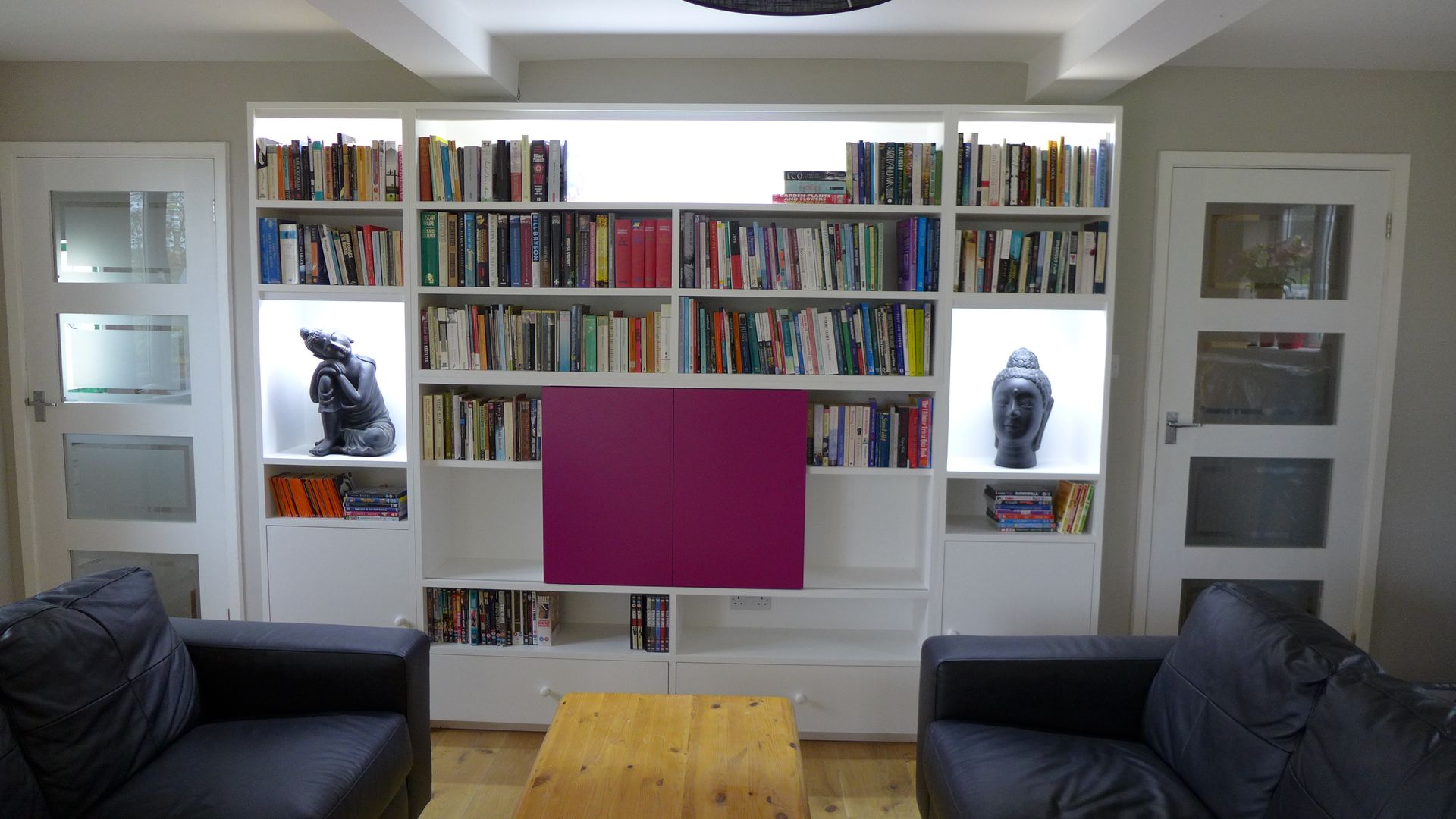 TV hidden in wall unit Style Within Salle multimédia moderne hidden TV,wall unit,wall storage,shelf lighting,alcove lighting,purple doors,sliding door unit,TV unit