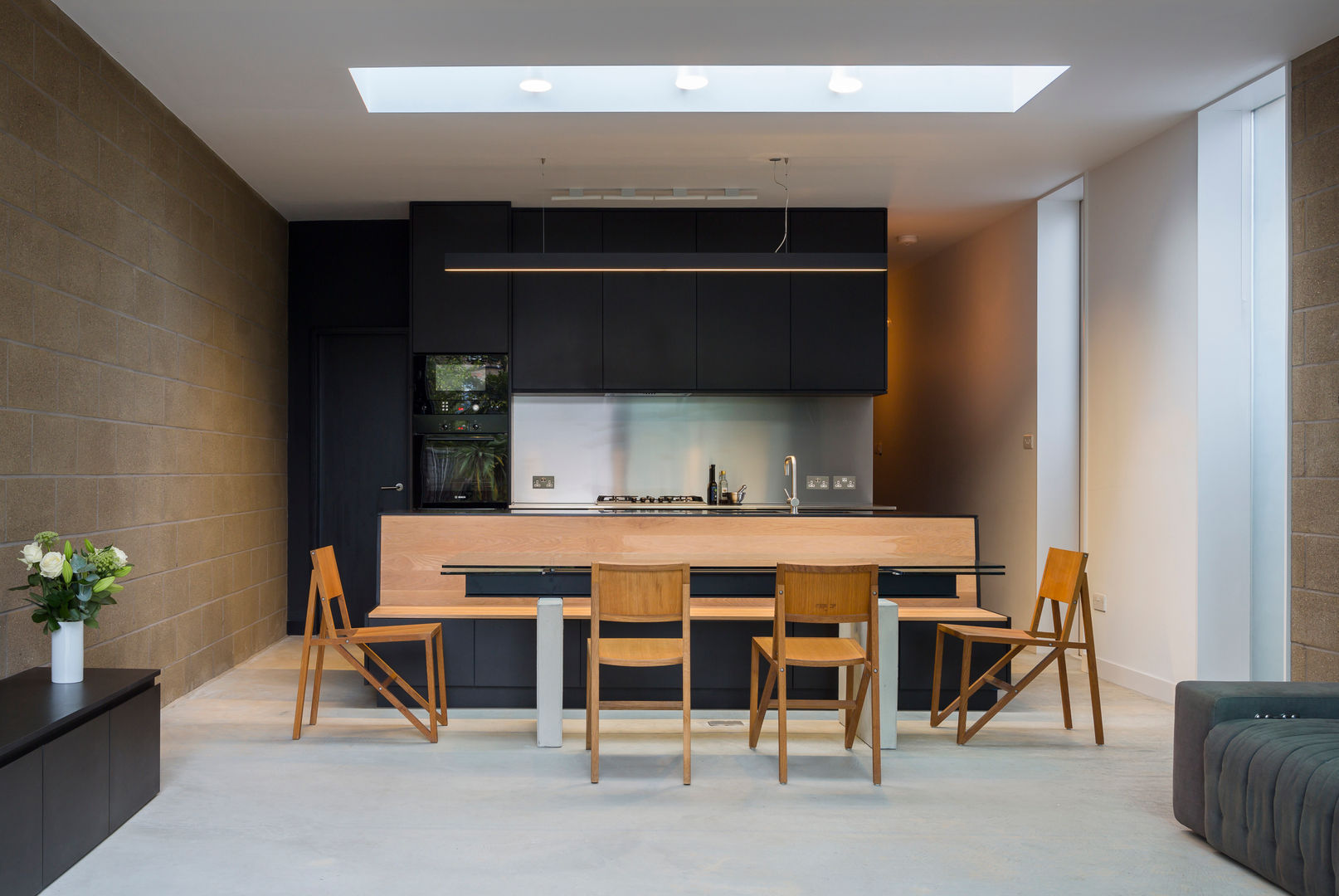 View of dining area with kitchen in the background Mustard Architects غرفة السفرة