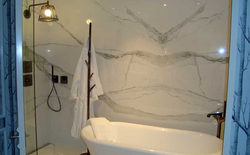 White marble effect book match porcelain tile create a stunning back drop to this freestanding bath homify Moderne badkamers Porselein Decoratie