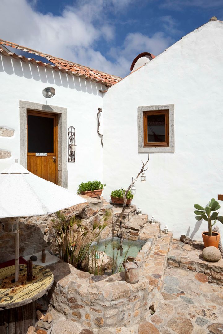 CASA EM FORMA DE ABRAÇO , pedro quintela studio pedro quintela studio Rustic style balcony, porch & terrace Stone