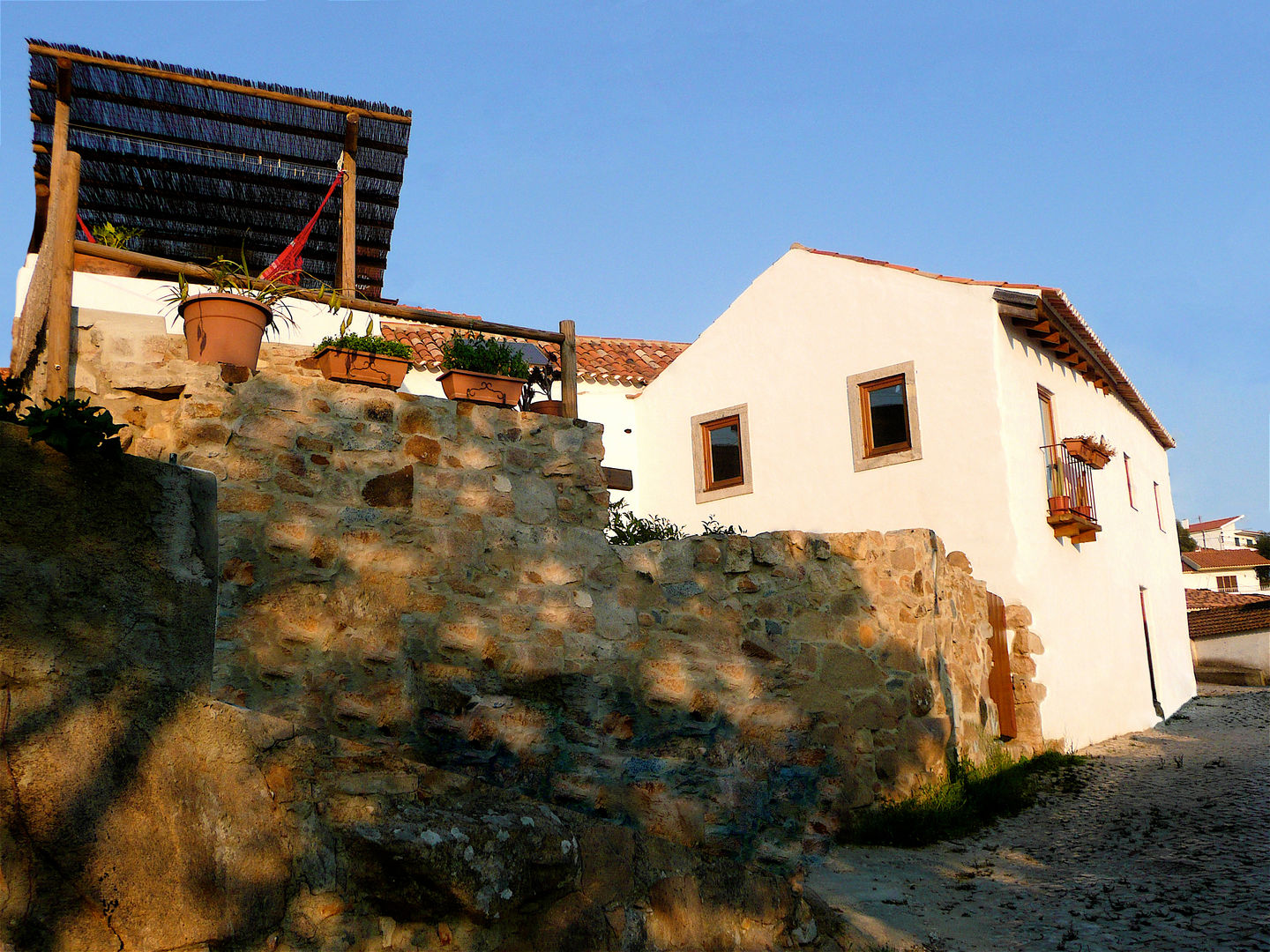 CASA EM FORMA DE ABRAÇO , pedro quintela studio pedro quintela studio ラスティックな 家 石