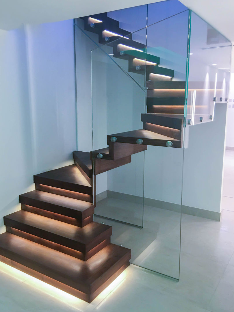Elegant zig-zag staircase features walnut-clad treads and risers. Railing London Ltd Corredores, halls e escadas modernos