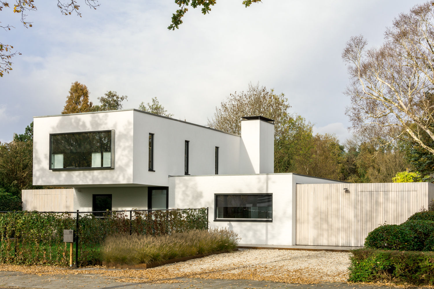 Luxe renovatie met zwevende dakopbouw, maatwerk keuken met zwevend HI-MACS keukenblok en houtfineer kastenwand, van Os Architecten van Os Architecten Casas modernas