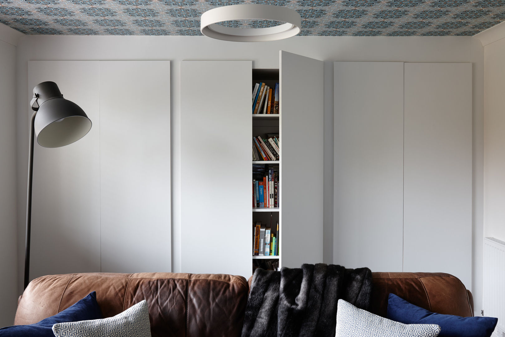 Virginia Water Apartment - Surrey Bhavin Taylor Design 모던스타일 거실 living room,wallpaper,furniture,storage,custom storage,cabinetry,pattern,ceiling lighting,lamp,blue,white