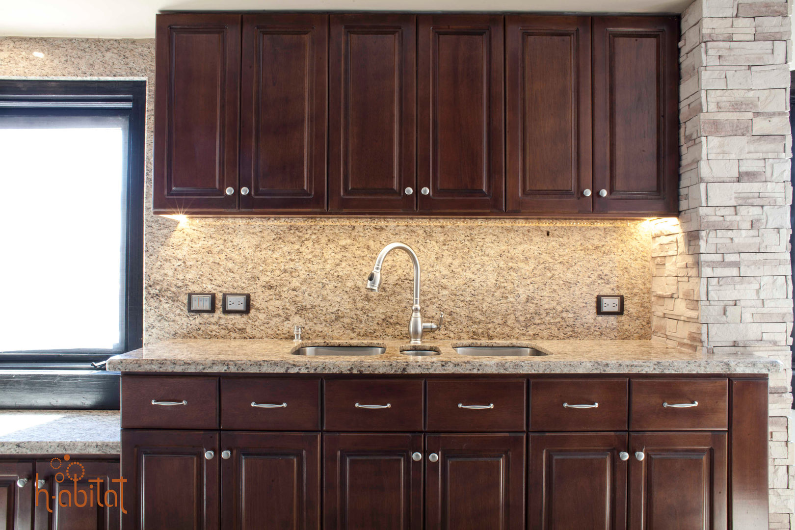Cubierta y muro de granito en área de fregadero H-abitat Diseño & Interiores Cocinas de estilo clásico Granito
