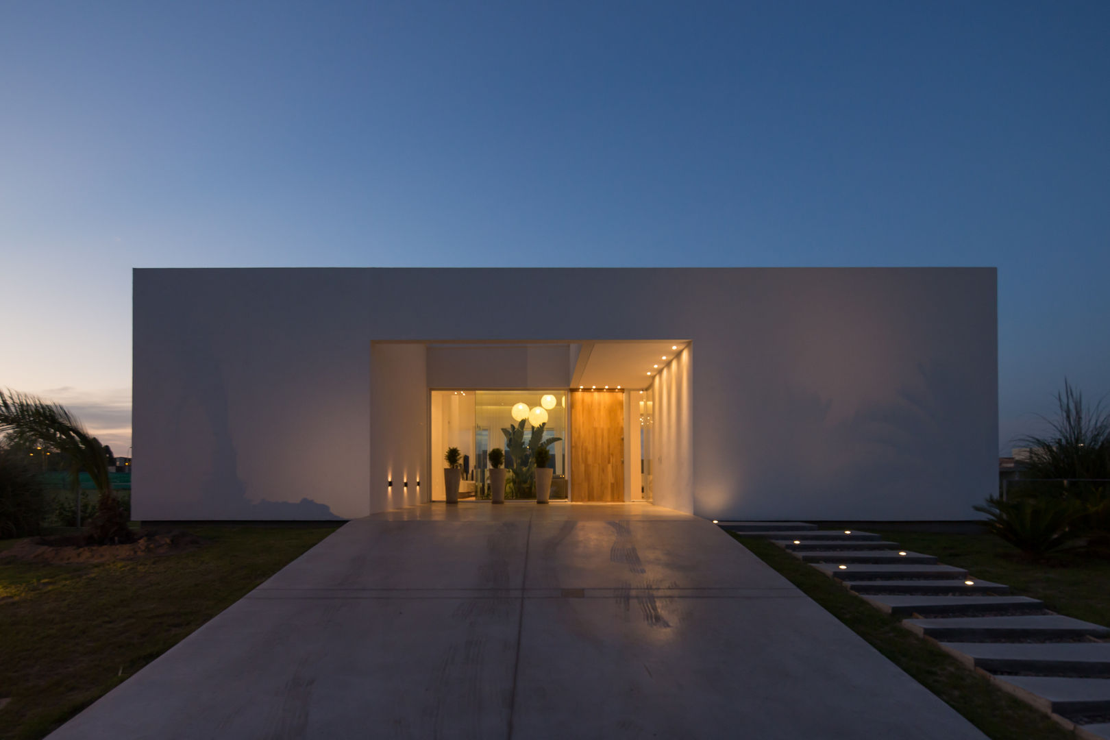 FACHADA SUR DE NOCHE VISMARACORSI ARQUITECTOS Casas de estilo minimalista