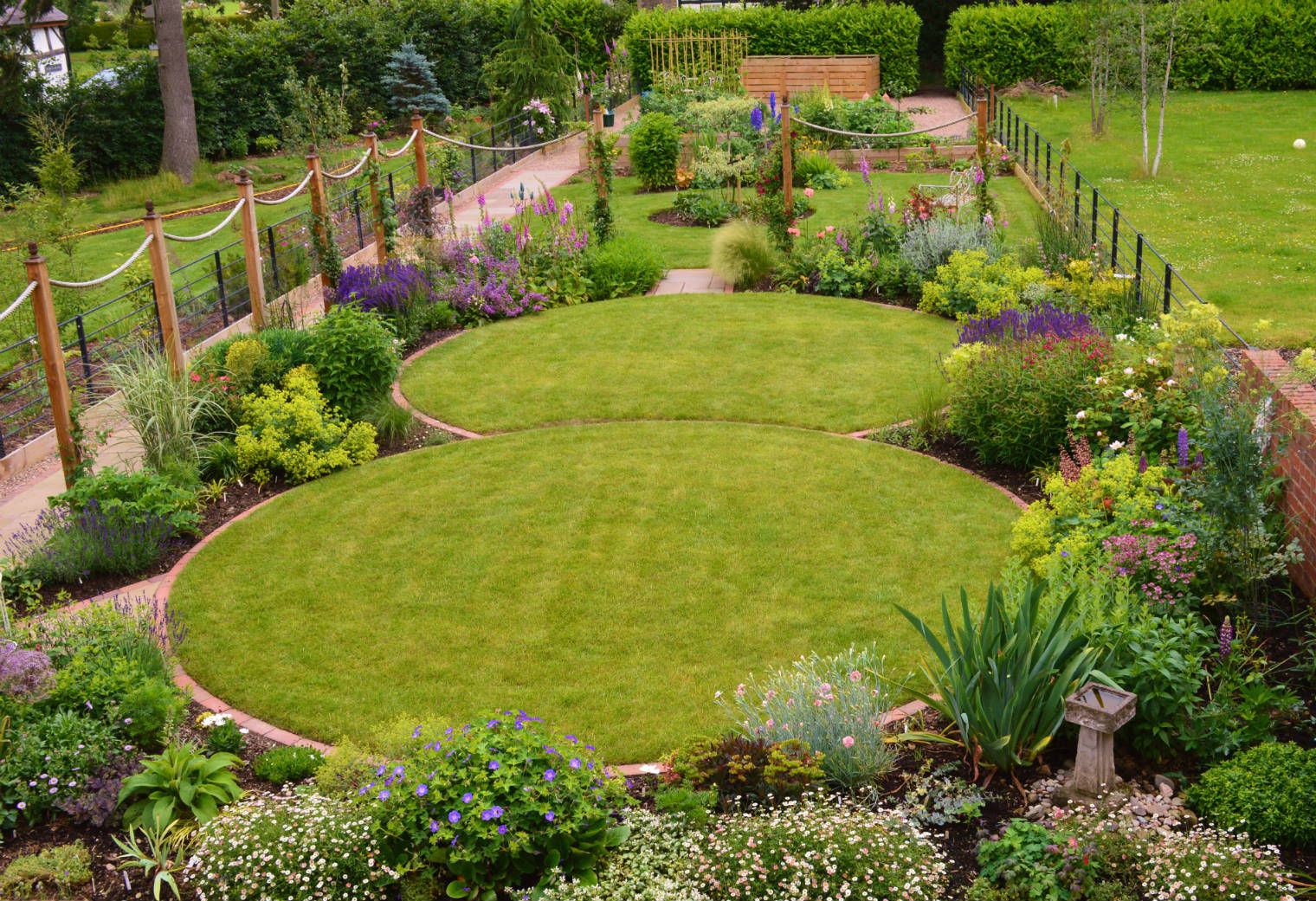 Circular lawns and traditional planting scheme Unique Landscapes حديقة circular lawns,traditional planting,timber posts,rope,lawn,country garden,traditional garden