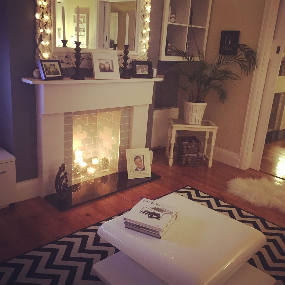 Family living homify Salas de estilo clásico fireplace,candles,side table,photo frames,cube shelving,house plants,coffee tables books