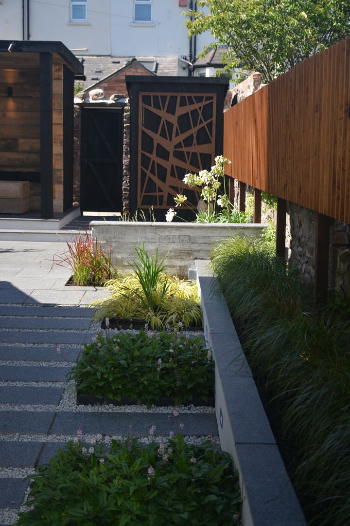 Black granite and concrete shutter board wall Robert Hughes Garden Design インダストリアルな 庭