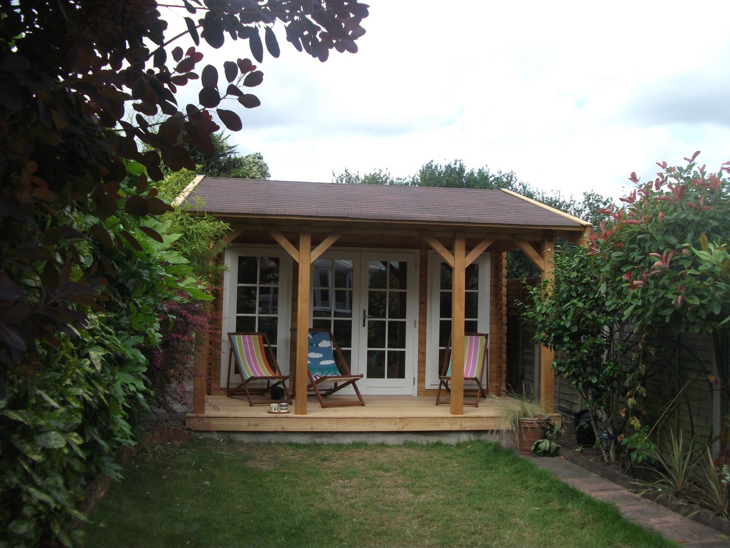 ​Scandinavian style log cabin. Garden Affairs Ltd สวน ไม้ Wood effect log cabin,scandinavian,garden room,veranda,outdoor living,summerhouse