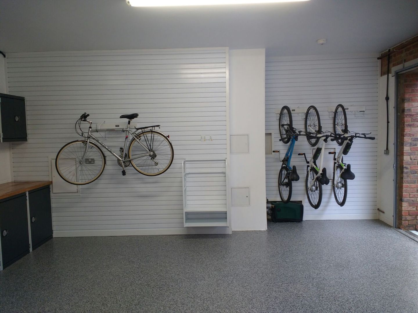 Resin Floor, Metal Cabinets and Bike Storage Galore in this lovely garage makeover in Cambridge Garageflex モダンデザインの ガレージ・物置 bike,storage,garage,garage door