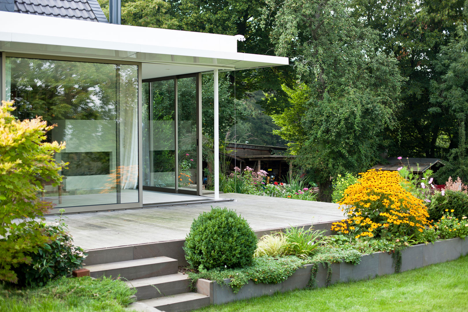 Wintergarten mit bodenbündigem Übergang in den Terrassenbereich raum.4 - Die Meisterdesigner Moderne Häuser