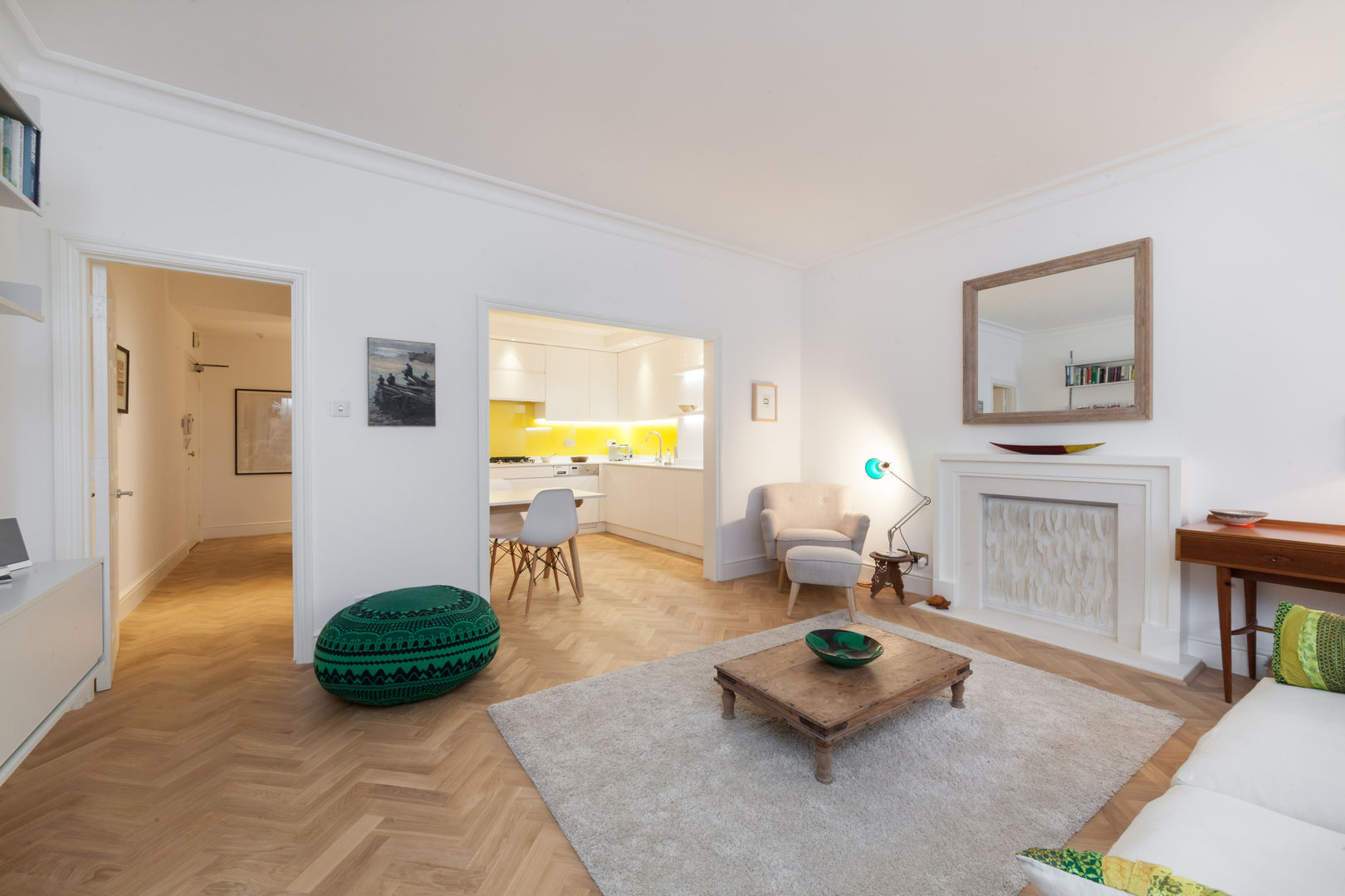 Open-plan living room with eclectic furnishings leading into kitchen homify Ruang Keluarga Gaya Eklektik Kayu Wood effect herringbonewoodfloor,parquetfloor,livingroom,rug,fireplace,yellowkitchen,whitekitchen,nottinghhill