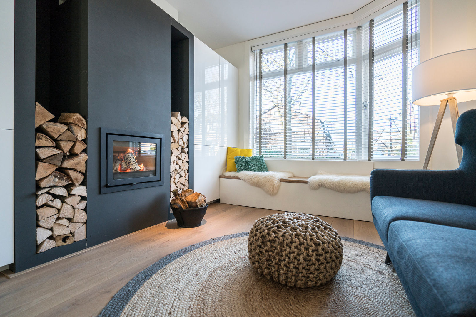 Houtkachel met houtvoorraad bij de erker Masters of Interior Design Moderne woonkamers Hout Hout Eigendom,Comfort,Raam,Bank,Textiel,Verlichting,Interieur ontwerp,Vloeren,architectuur,Vloer