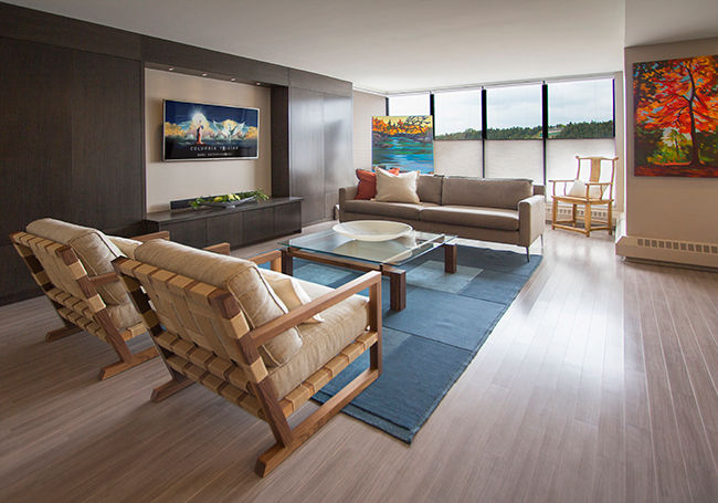 Living Room Kevin Gray Interiors Living room blue area rug,glass coffee table,wood floor,grey cabinets,colorful painting,entertainment unit,concealed storage