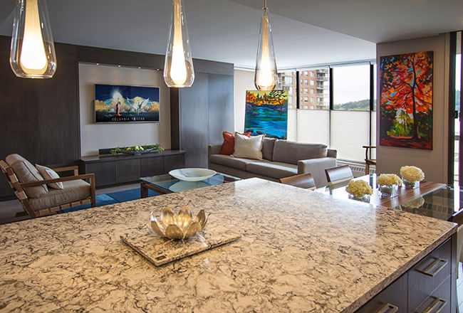 Island and eating area Kevin Gray Interiors Comedores de estilo moderno quartz countertop,glass pendant lamps,grey cabinets